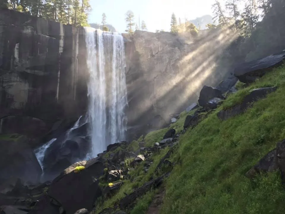 Waterfall pouring over a steep cliff with water mist rising into the air
