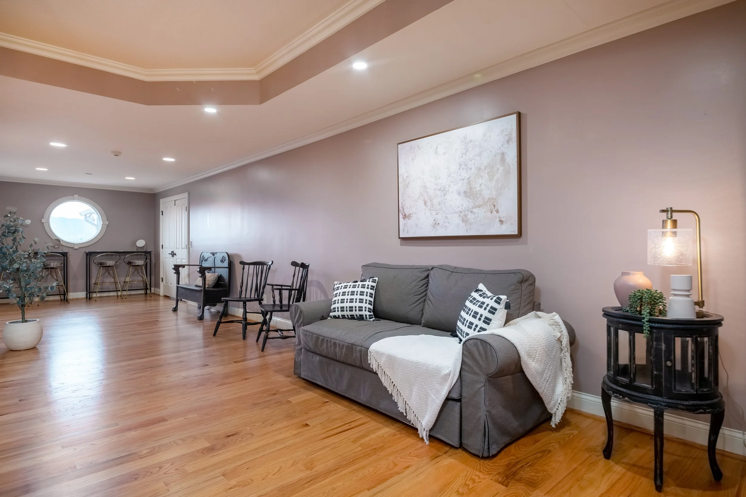 The expansive primary suite at the Ocoee RIver Estate features a sitting area with a porthole window overlooking the Ocoee River