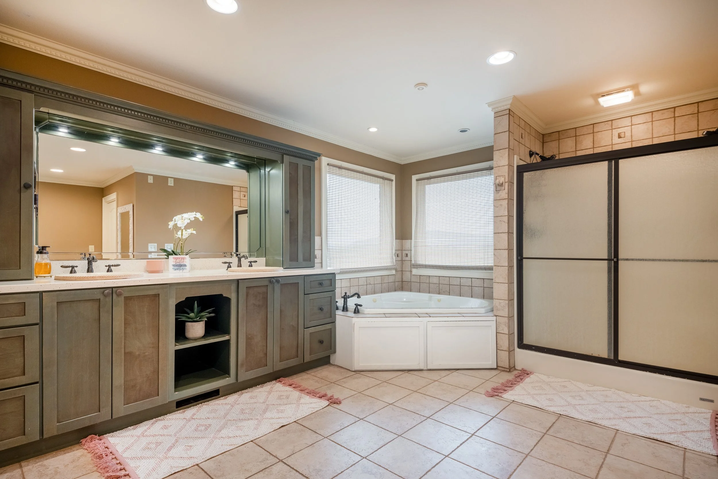 The Primary Bathroom at the Ocoee River Estate features a garden tub with windows overlooking the Ocoee River and the mountains beyond