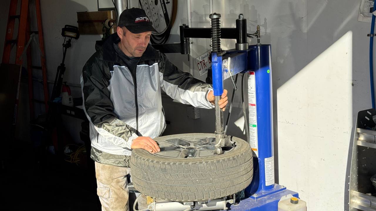 Mechanic servicing a tire on a tire changing machine at Spectrum Truck Services