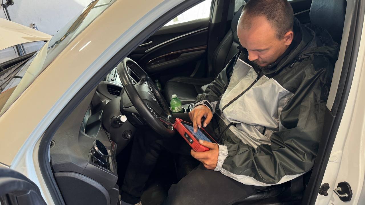 Mechanic using a diagnostic tablet to check vehicle electronics