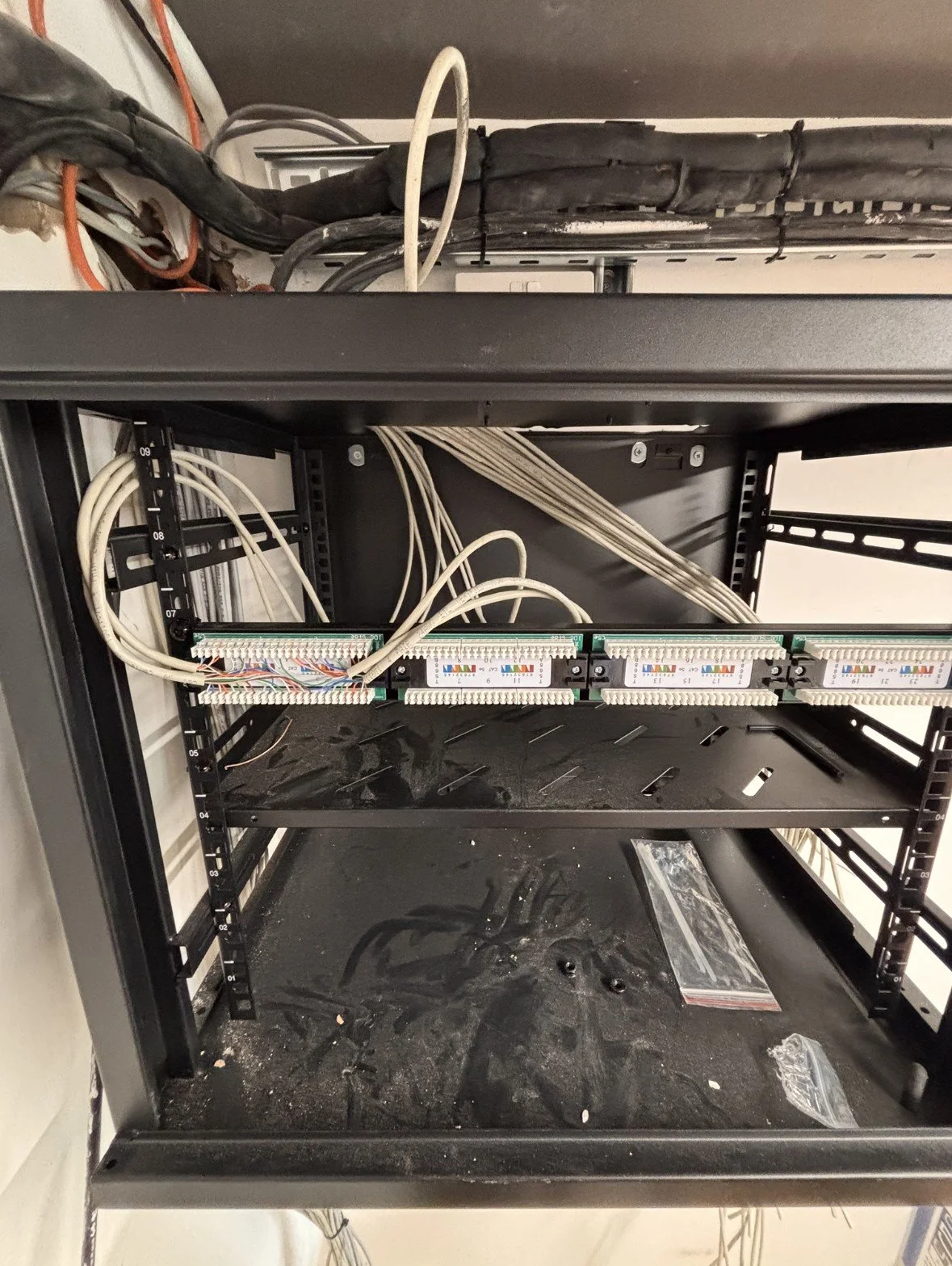 Construction or telecom rack with wired connections and empty slots.