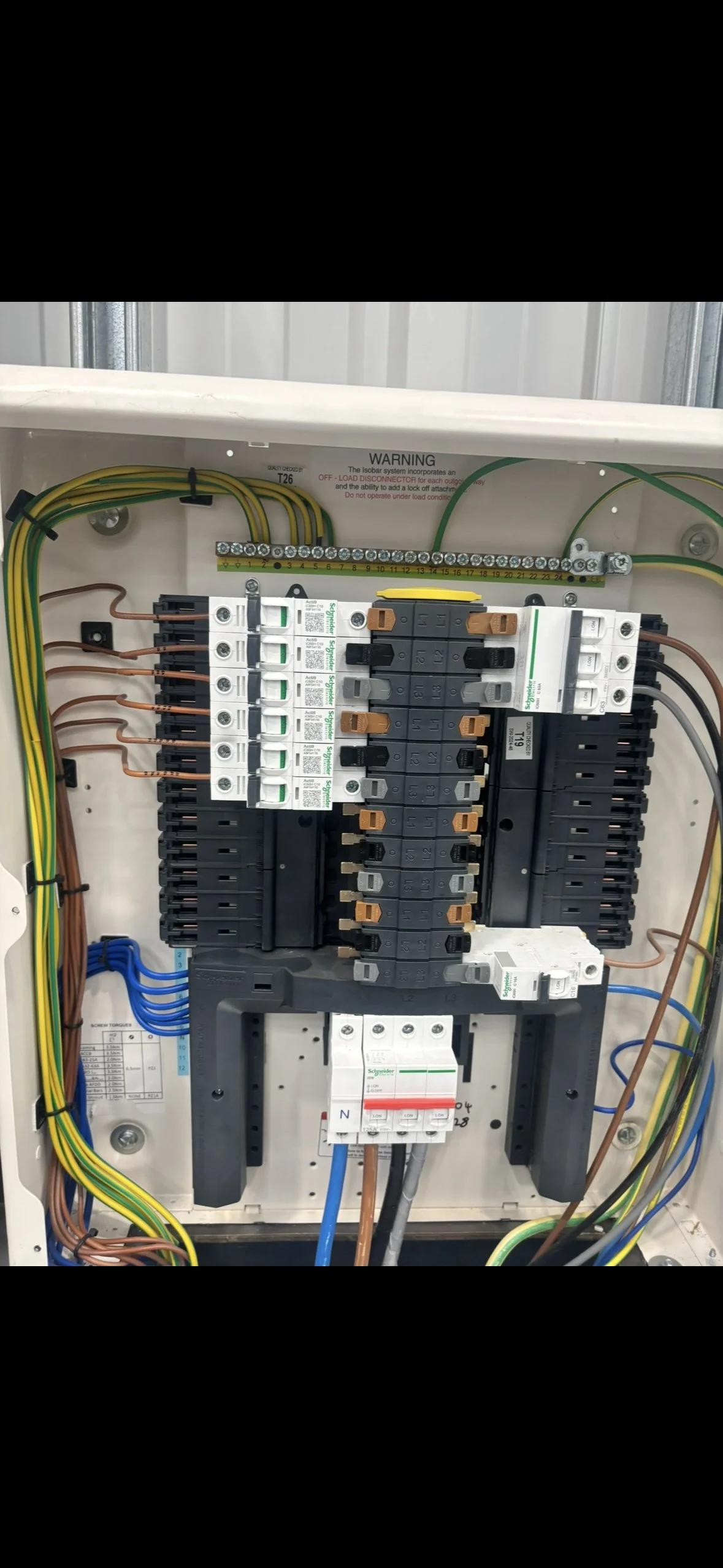 Electrical breaker box with various circuit breakers, wires, and wiring connections inside a metal enclosure.
