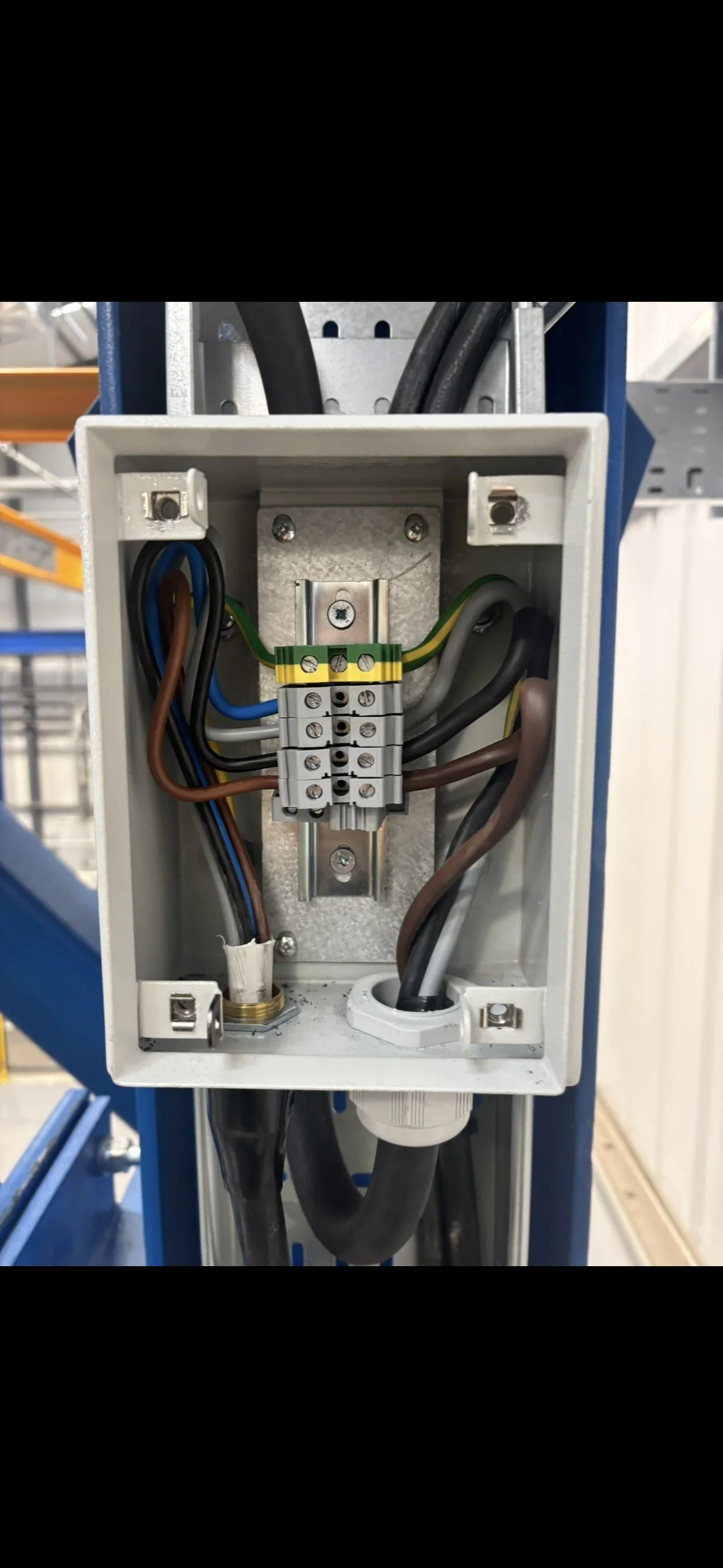 Close-up of an electrical junction box with multiple wires connected and a terminal strip inside