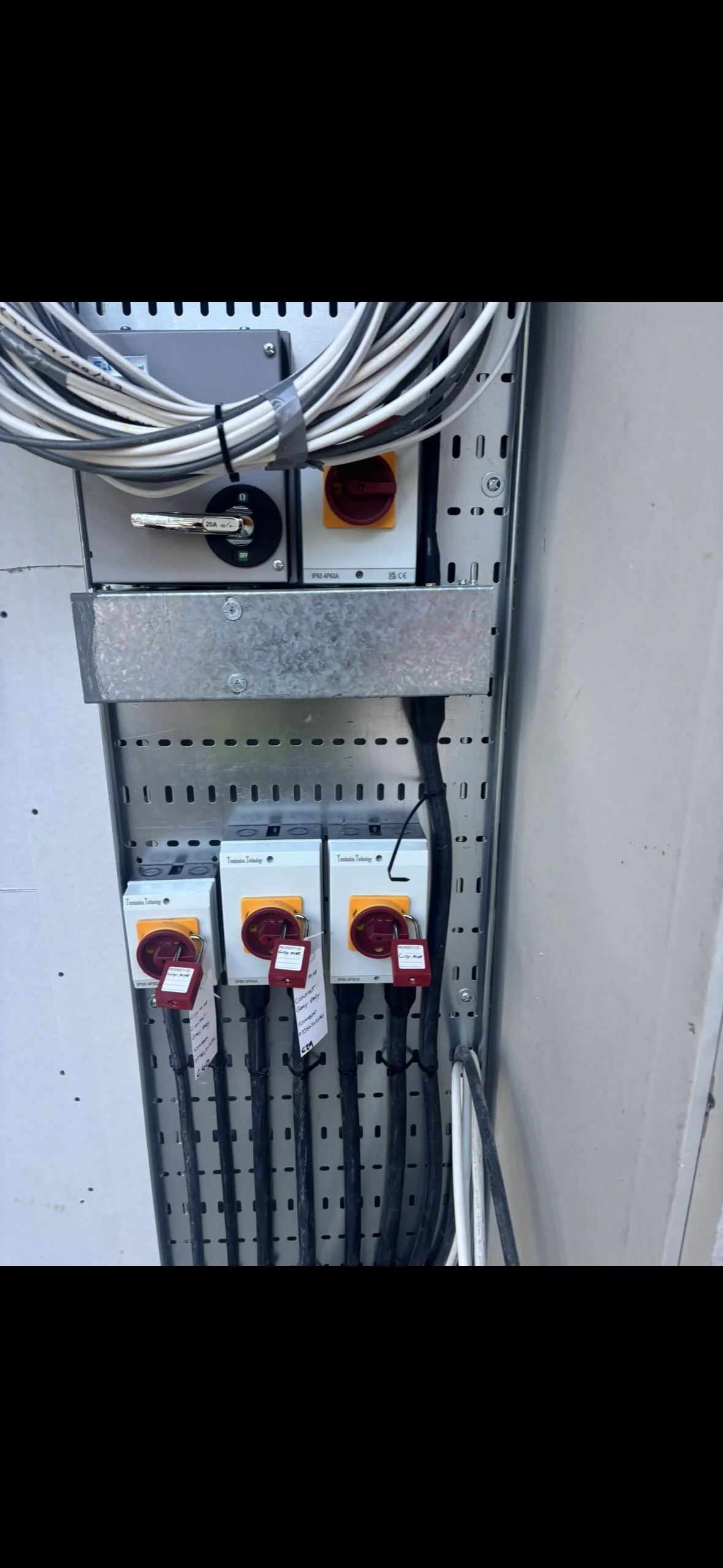 Electrical control panel with multiple circuit breakers, power outlets, and connected cables.