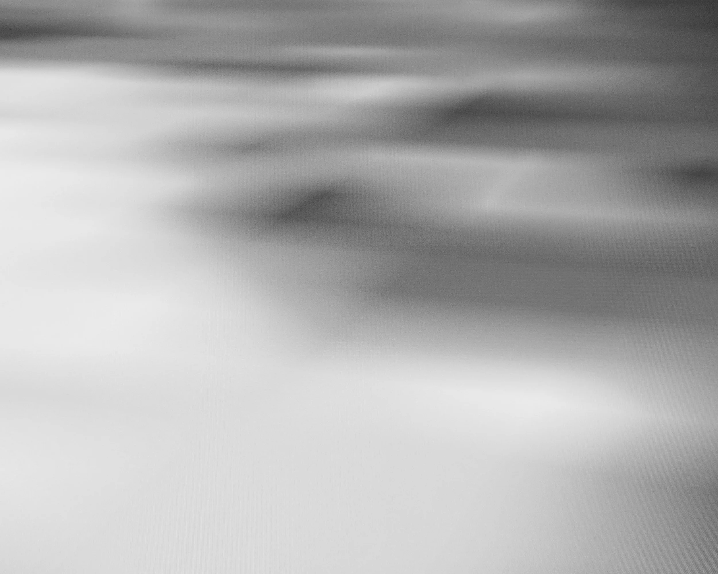 A black and white abstract photo with blurred and streaked textures.