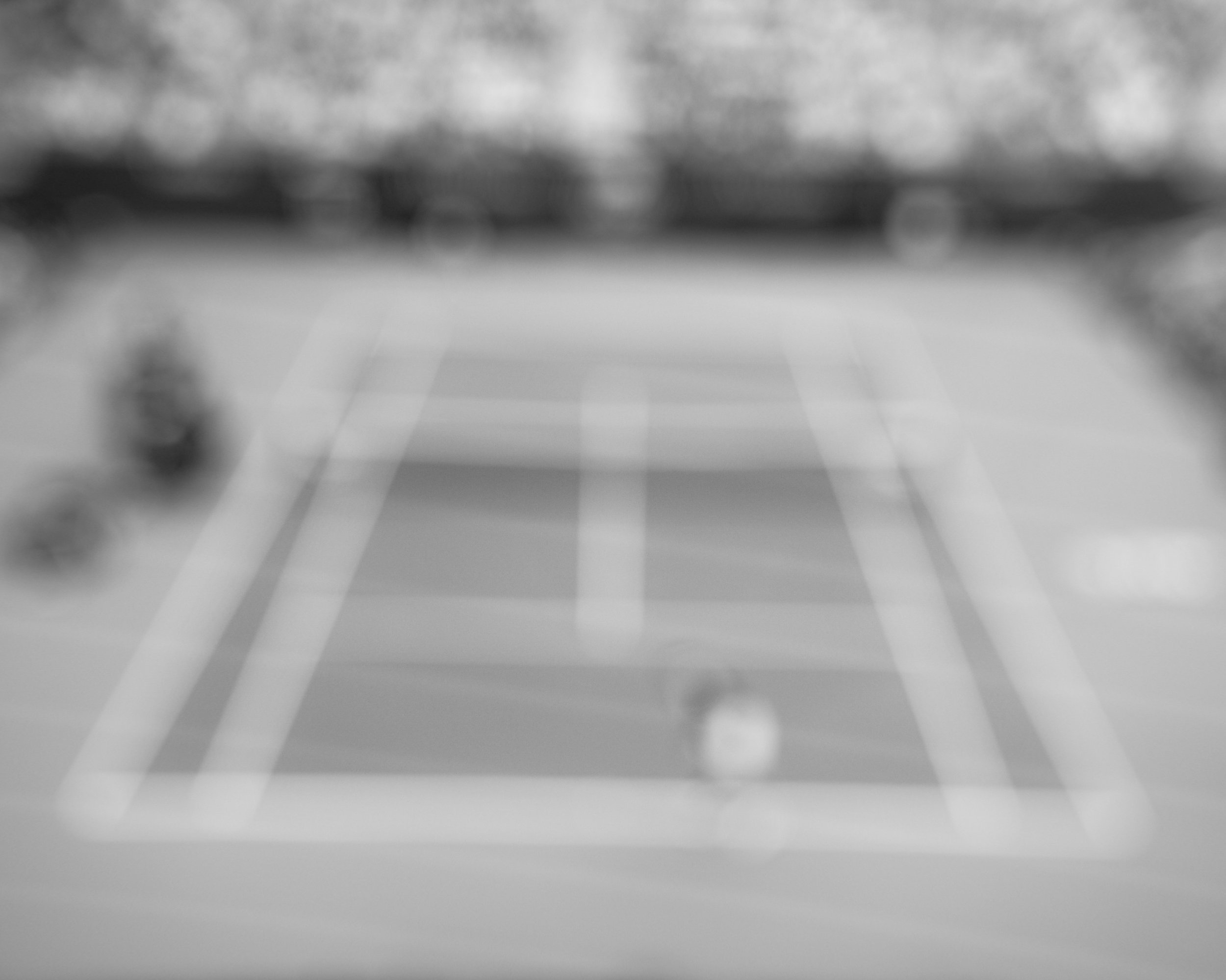 Blurred image of people walking on a sidewalk in a city.