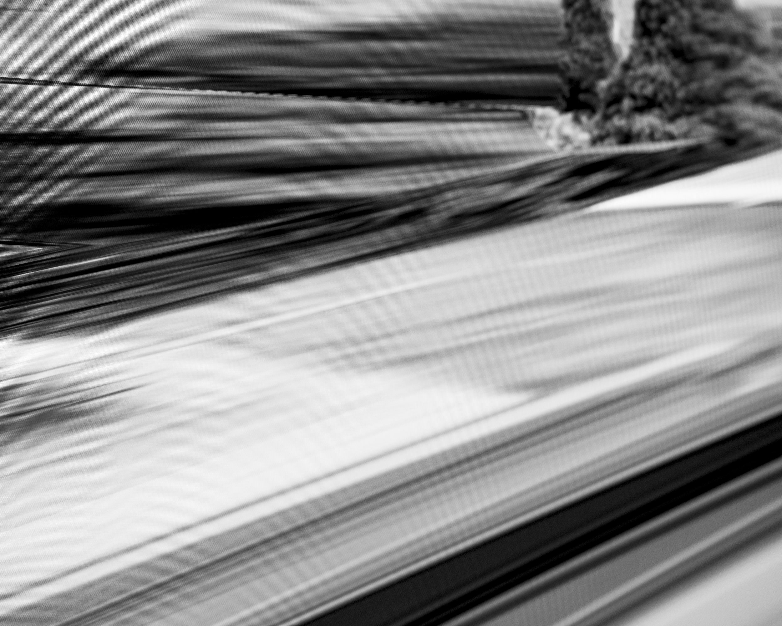 Black and white close-up of stacked sheets of paper with a blurred background.