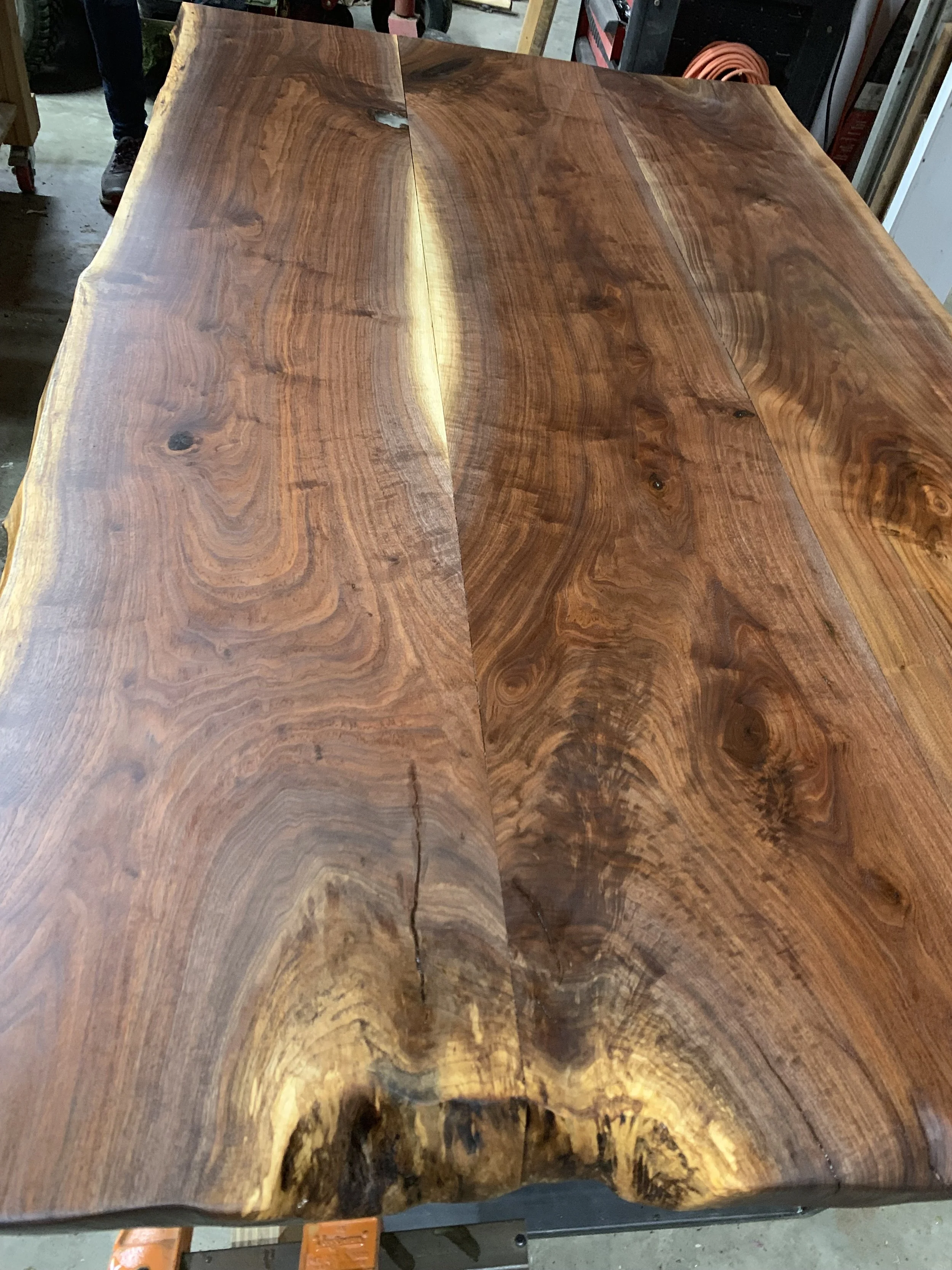 A wooden table with a natural, polished finish showing rich grain patterns and knots.