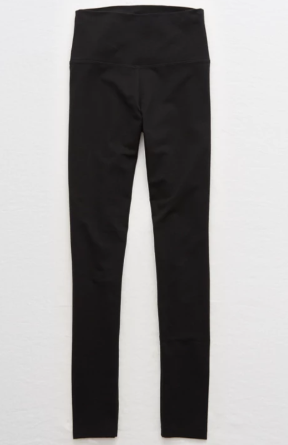 Black pair of high-waisted leggings hanging against a white background.