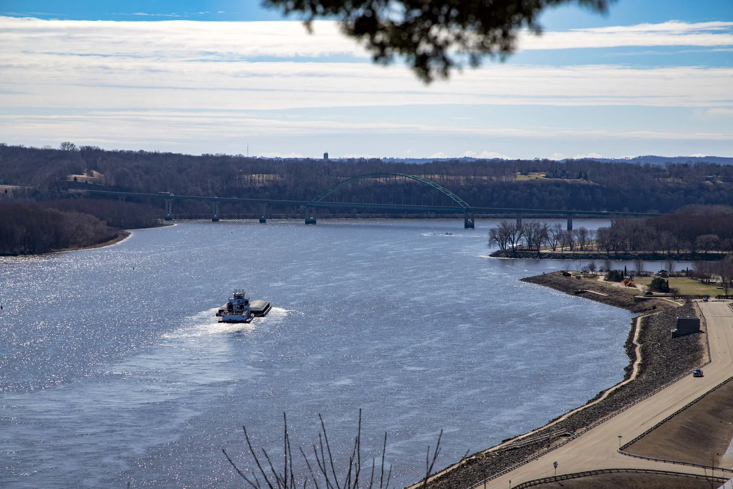 Cargo ship sailing on a river approaching a bridge