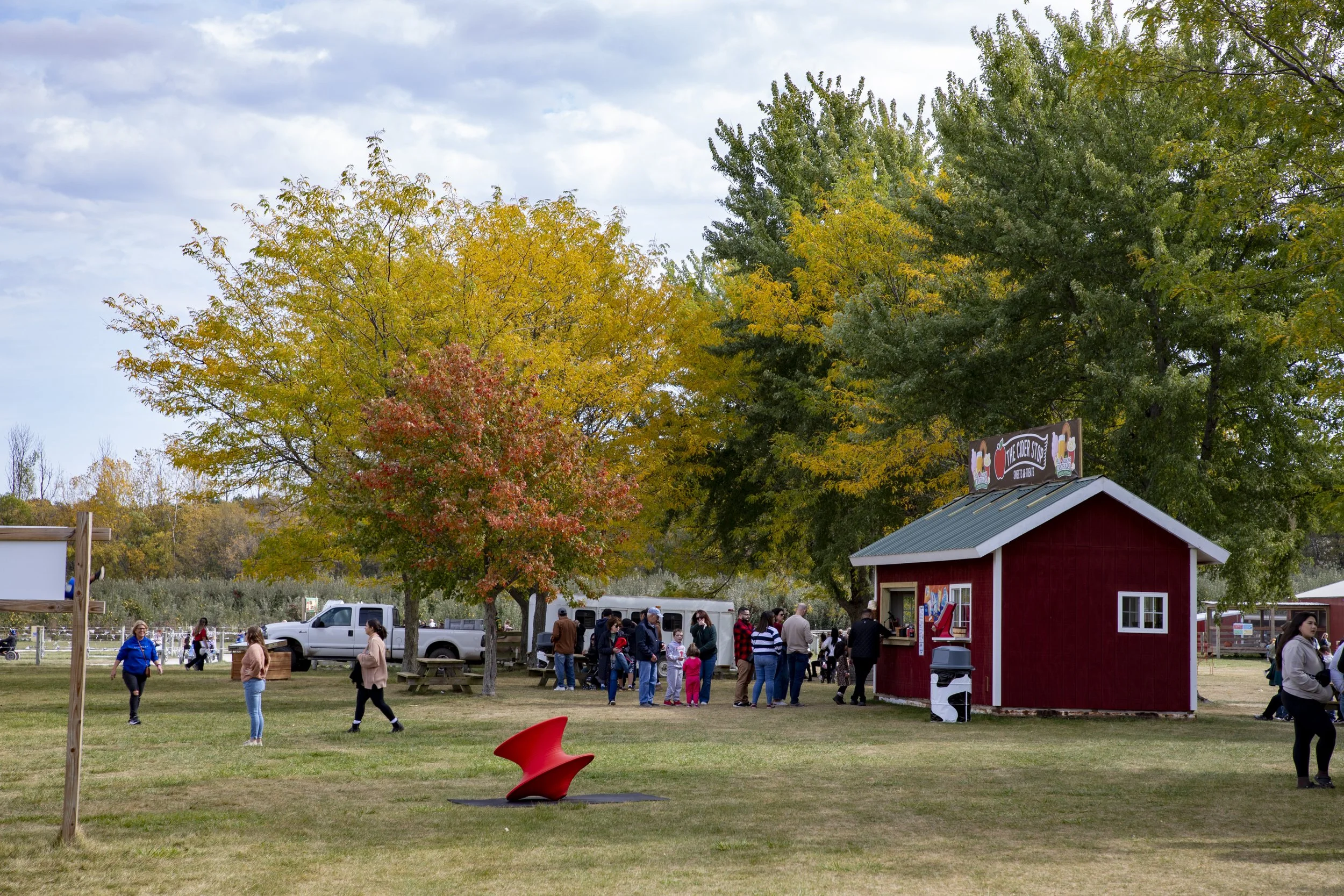 A food stall surrounded by trees with leaves of various colors.