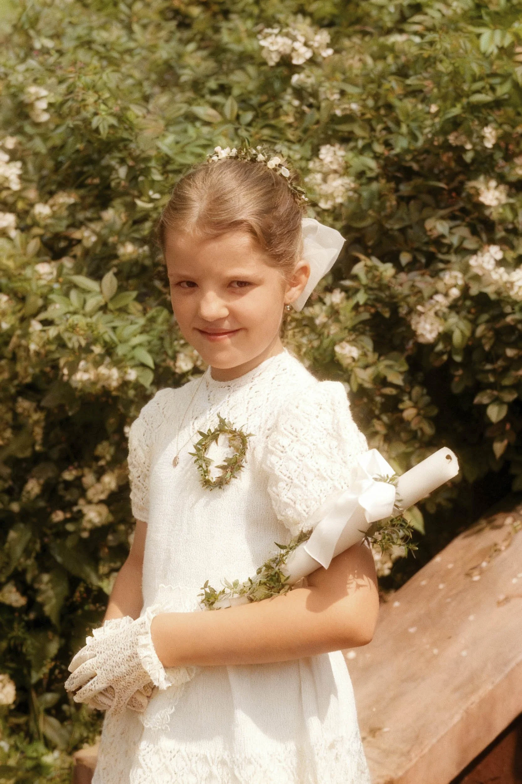 Colorized interpretation of a girl wearing a white dress and gloves, holding a rolled document beside flowering shrubs.