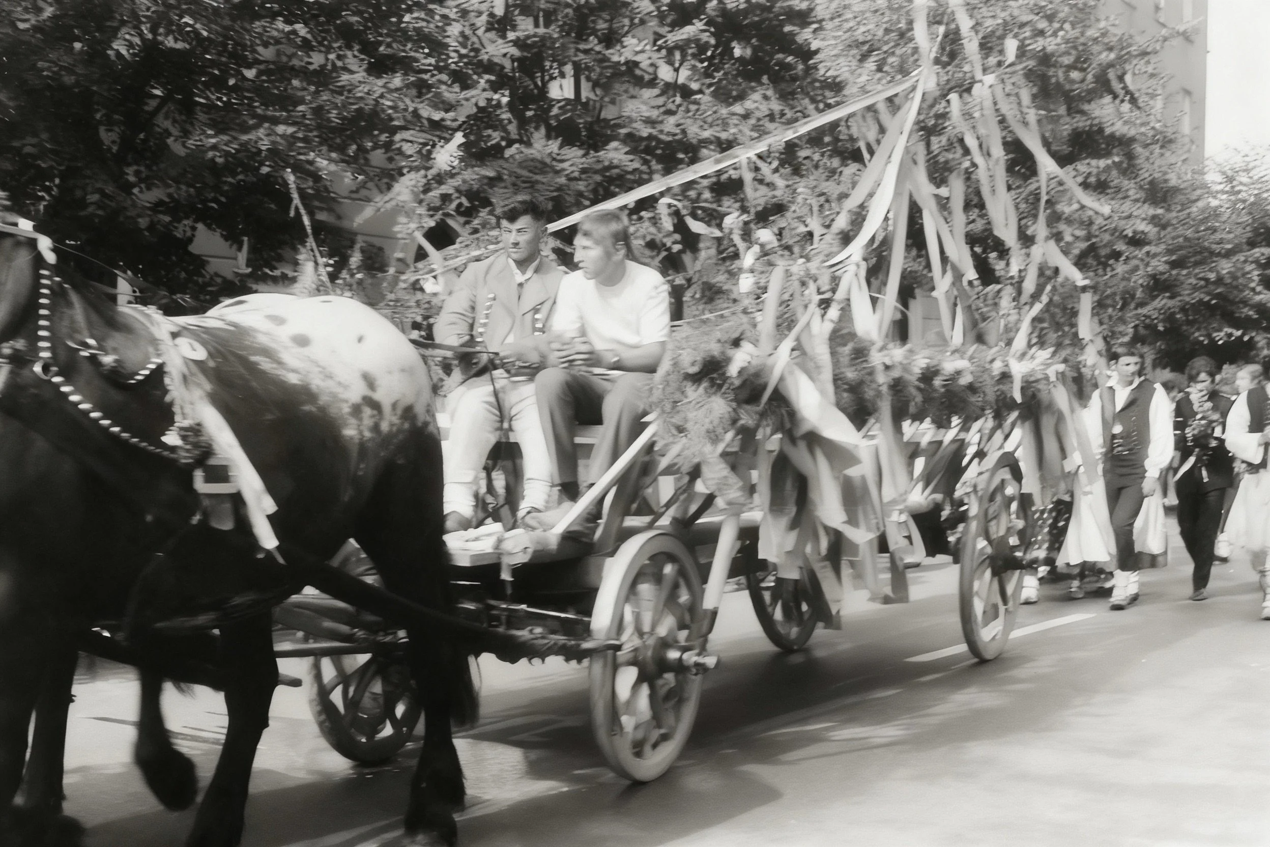 Black-and-white photograph of a horse-drawn wagon decorated with branches and streamers.