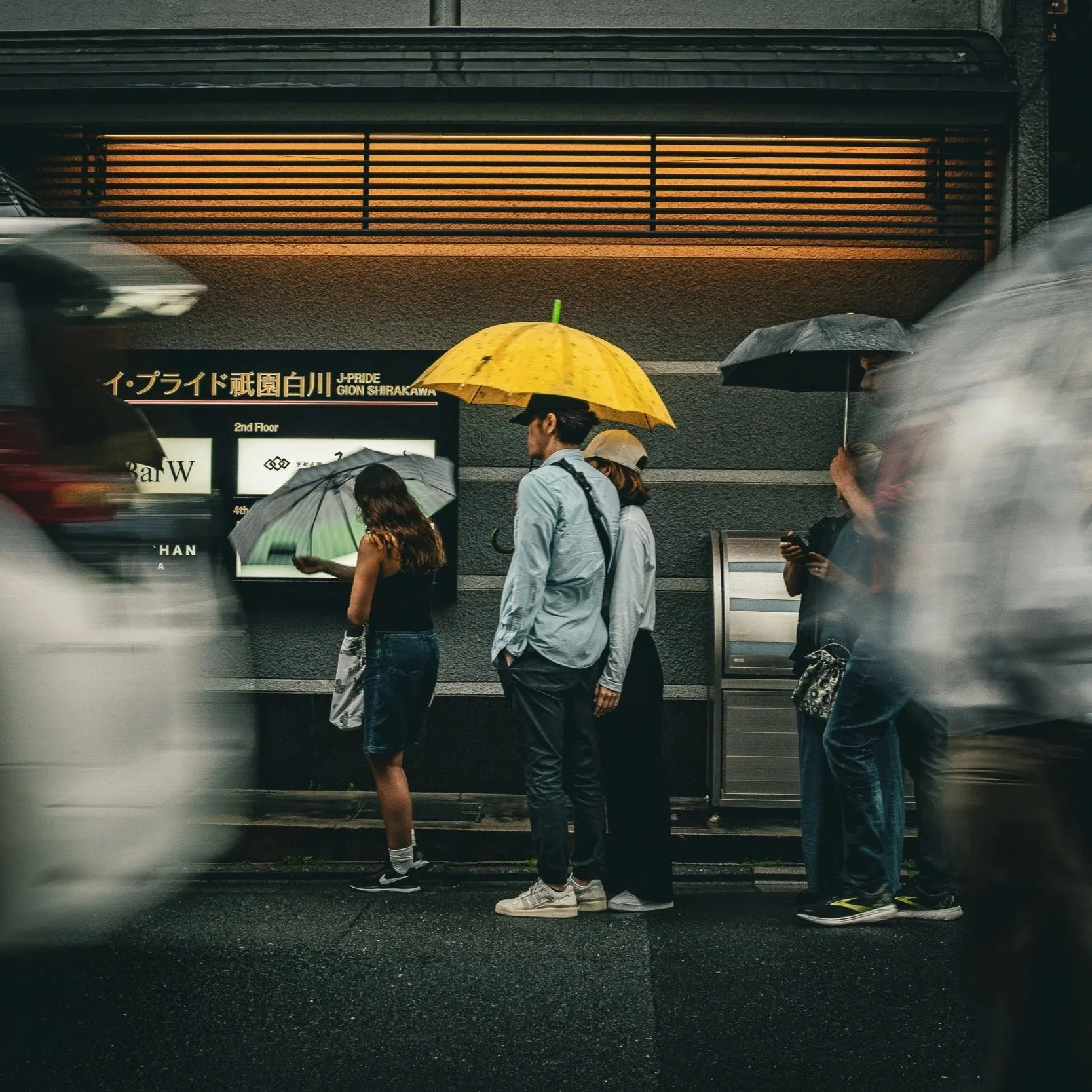 People with umbrellas on a rainy street — explore reportage photography.