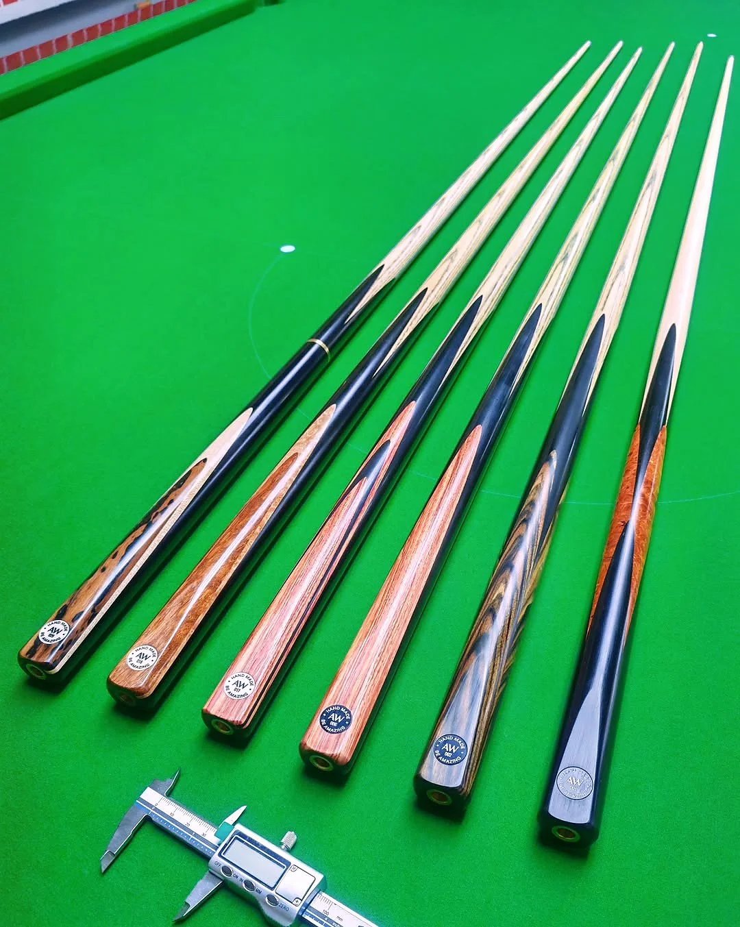 AW147 custom snooker cues with contrasting timber splices on green baize