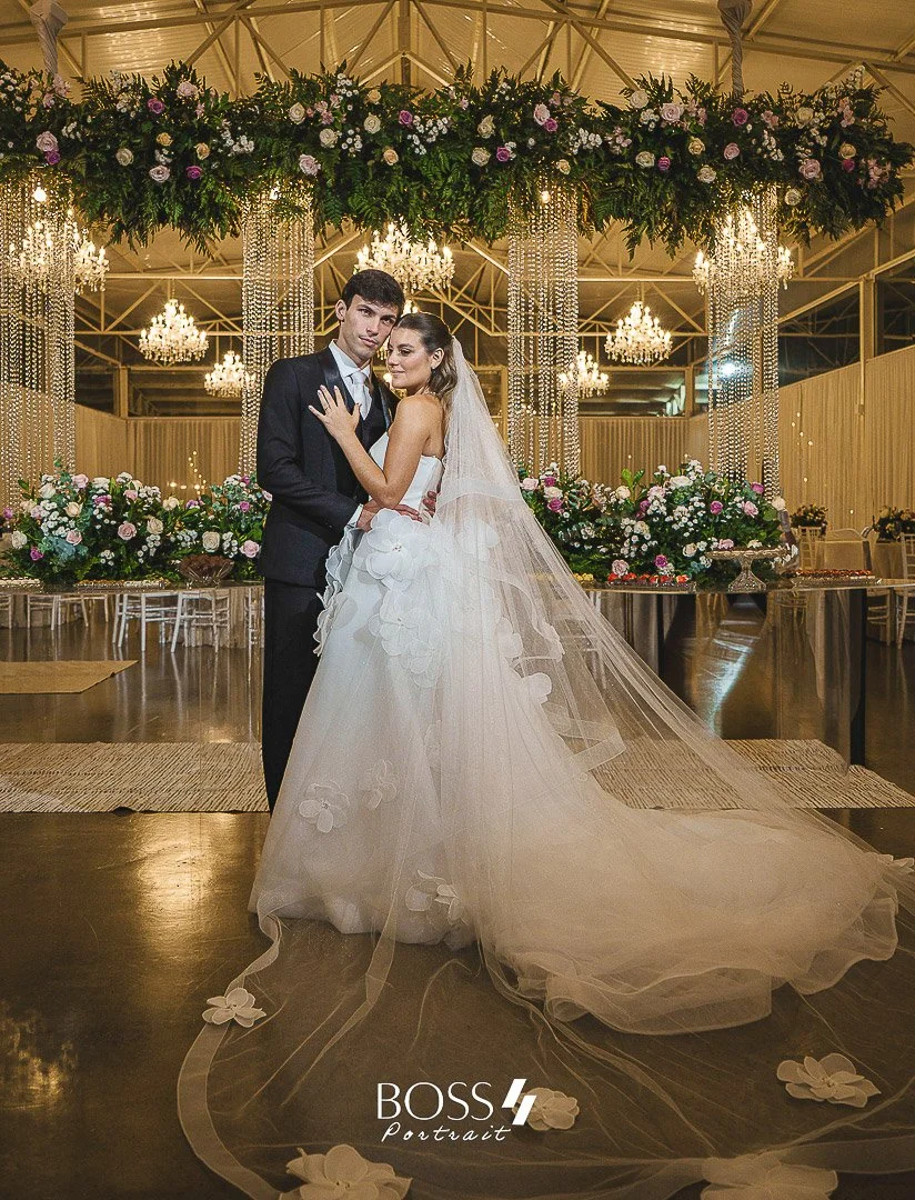 Casal de noivos em casamento, com decoração elegante de flores e cristais na festa.