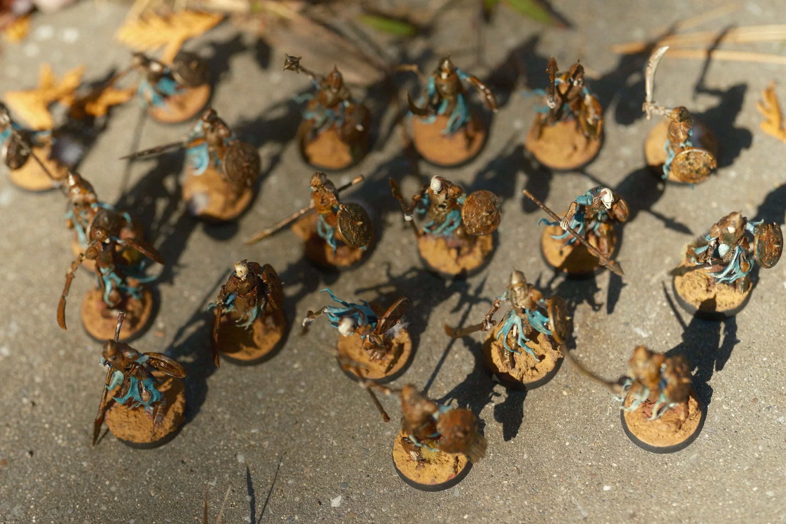 Miniatures de soldats en armor, équipés de boucliers et d'épées, alignés sur une surface de jeu.