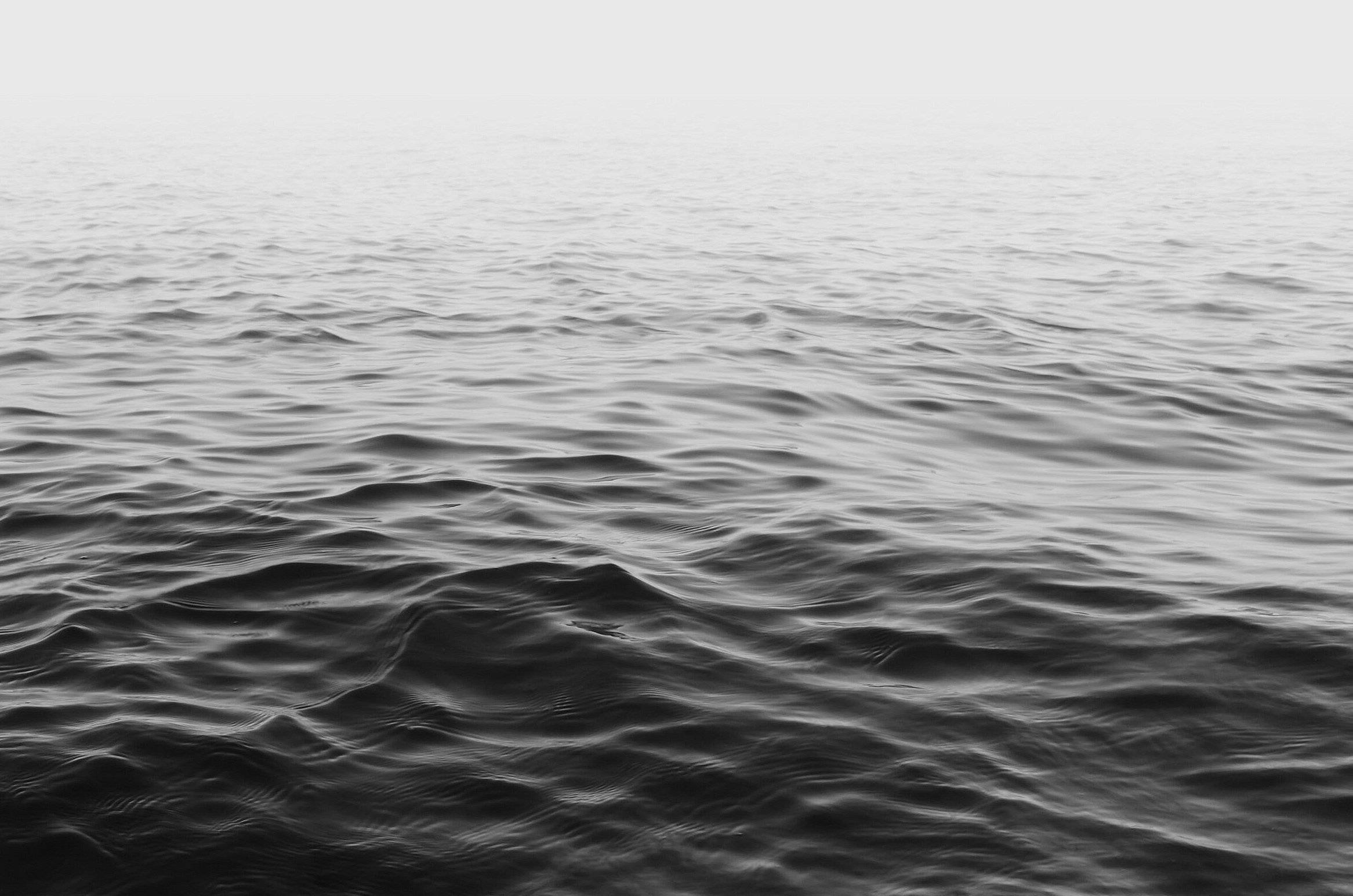 Black-and-white photograph of rippling water fading into mist.