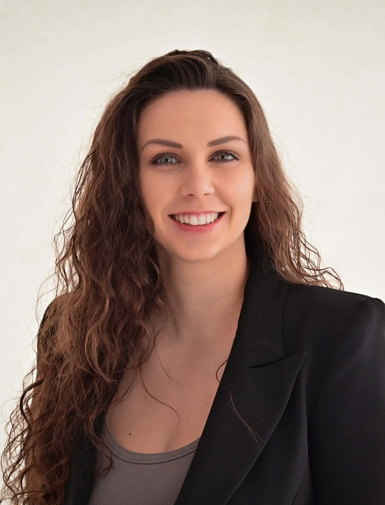 Gründerin von Cash&Coffee Esmeralda Burtscher trägt einen schwarzen Blazer und lacht in die Kamera.