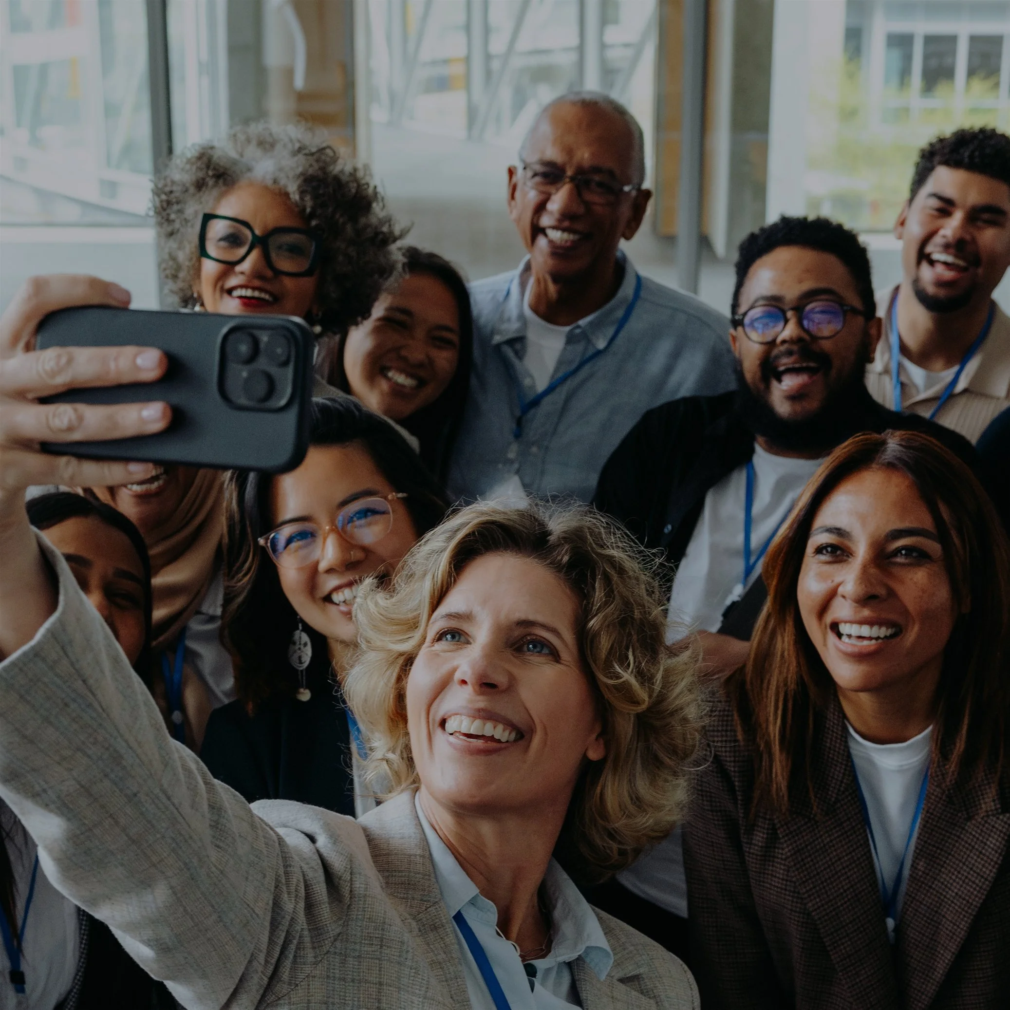 Diverse group of smiling professionals taking a selfie indoors