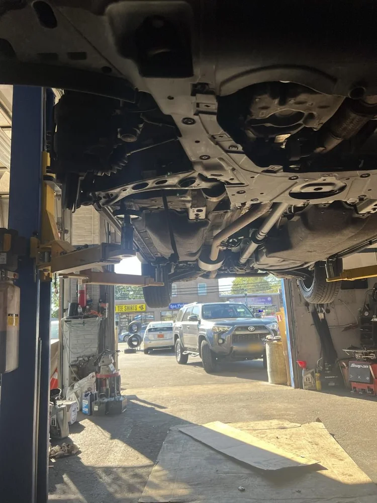 Inspecting the underside of a car on the lift at RAFL Motors
