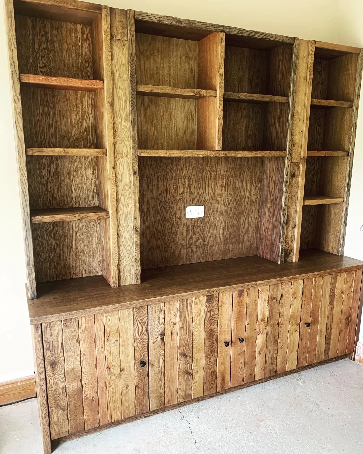 Wooden bookshelf with multiple shelves and cabinet doors at the bottom.