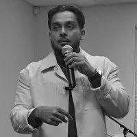 Man speaking into a microphone in an indoor setting