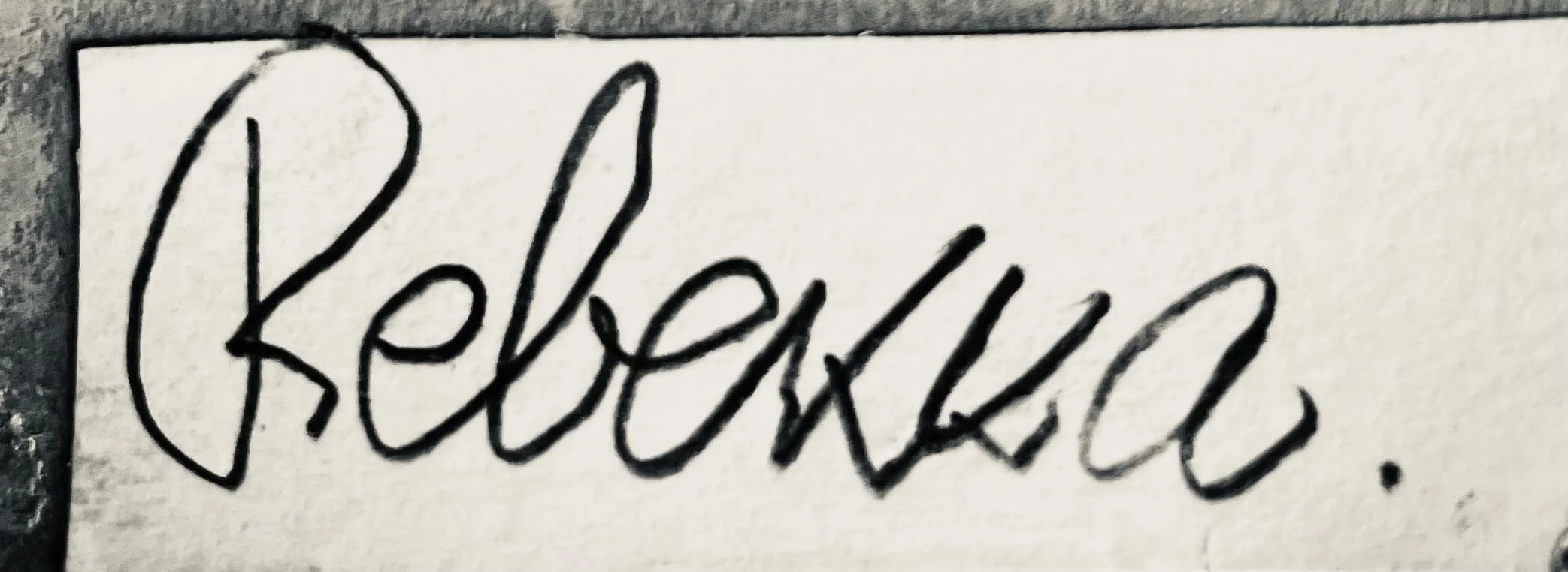 Handwritten black cursive word "Believe" on white paper