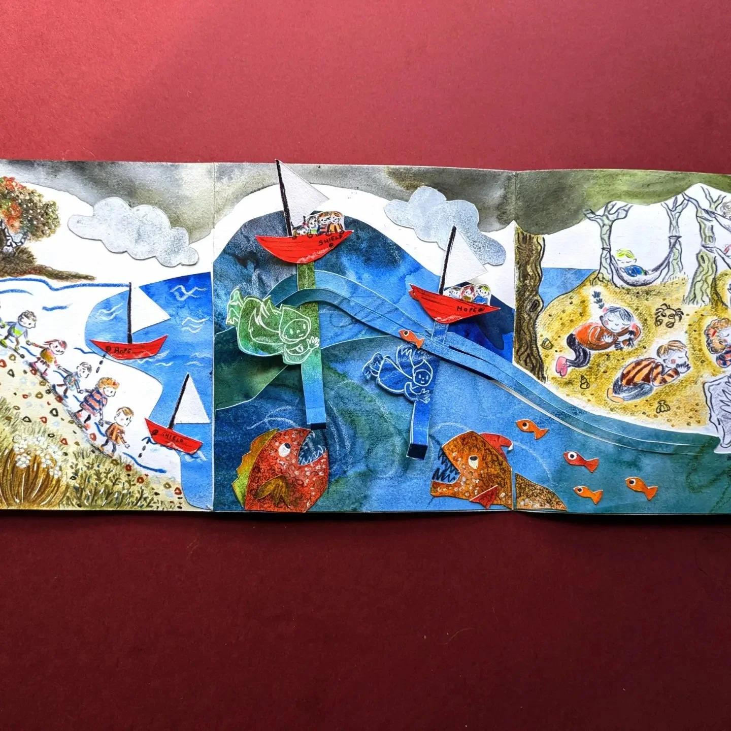 Colorful children's collage artwork with paper cutouts of boats labeled 'Shields' and 'Hope,' children sleeping on a beach, animals, mountains, and a forest scene with angels.