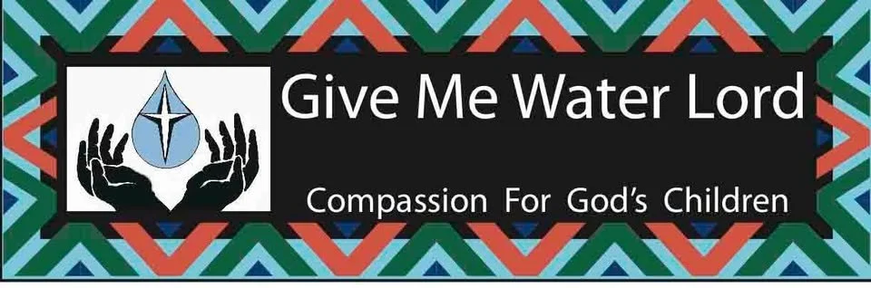 A colorful patterned banner with a black rectangle containing white text that reads "Give Me Water Lord" and smaller text below that says "Compassion For God's Children." The banner also features an icon of two hands holding a water droplet with a cross inside the droplet.