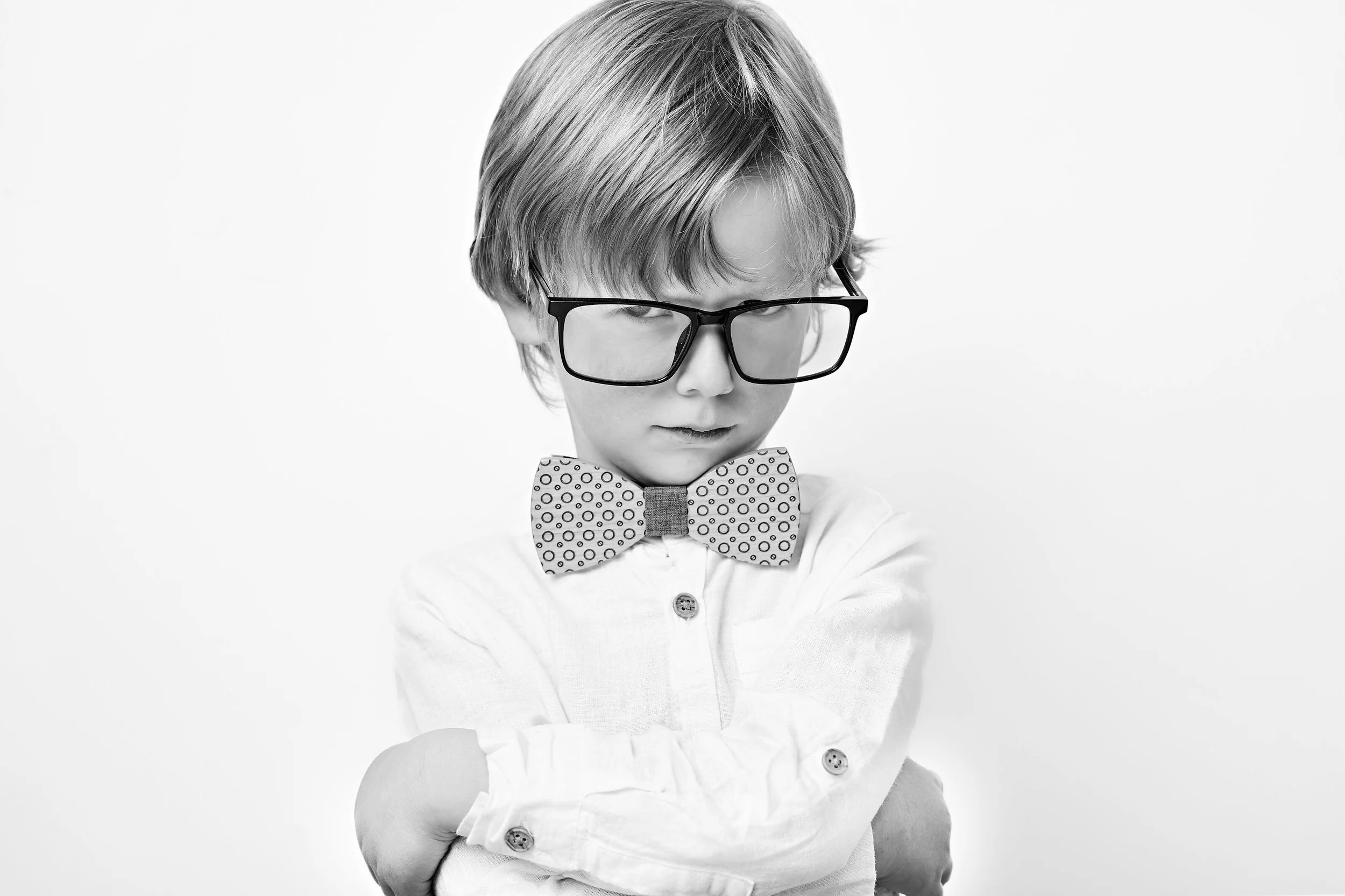 A charming black and white children's studio portrait showcasing individuality, character and playful personality. Discover elegant and creative children's photography with Lucas Gudaniec Photography, serving families across Annecy and Geneva.