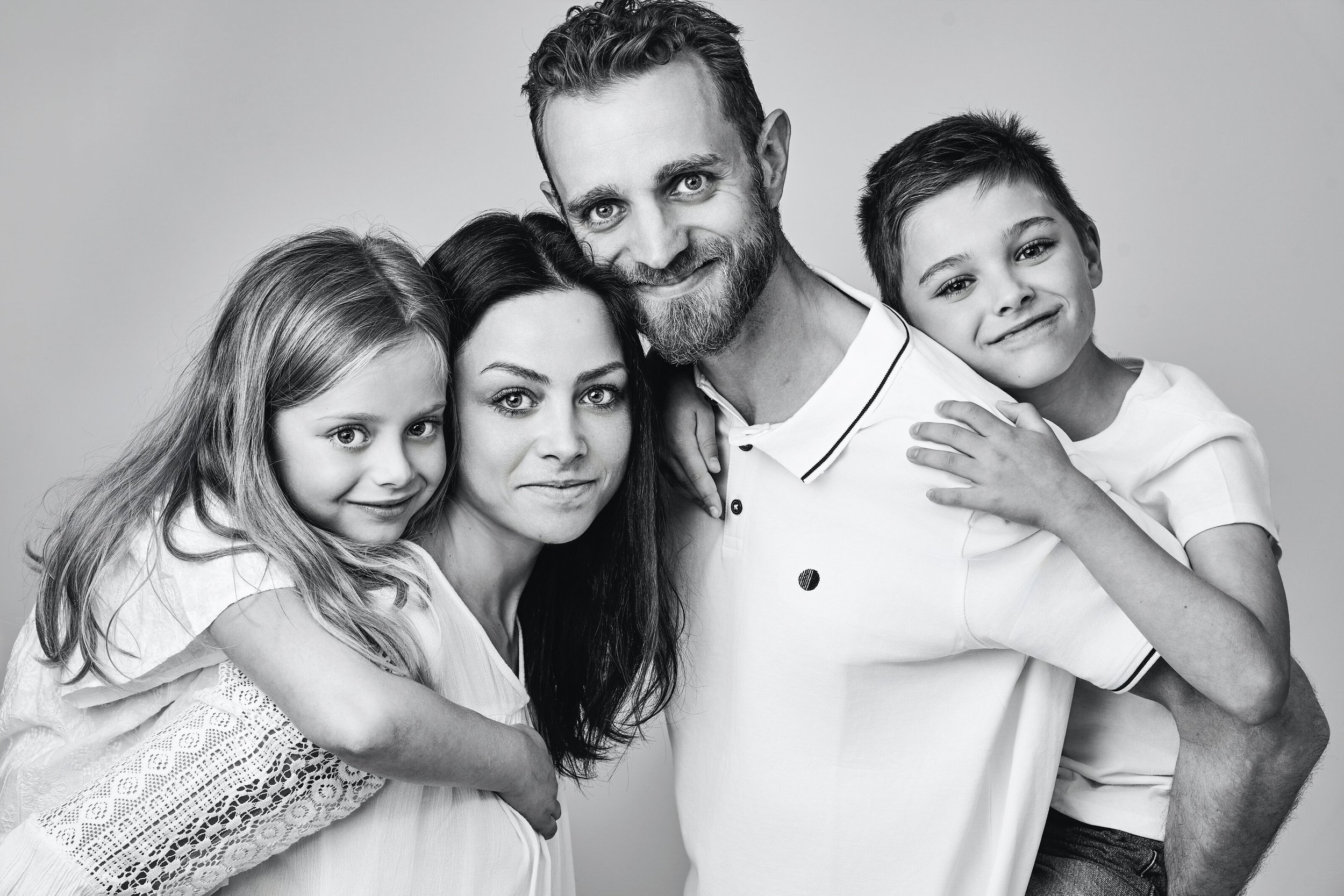 Timeless black and white family studio photography capturing genuine smiles, beautiful connections and precious family memories. Luxury family portrait experiences by Lucas Gudaniec Photography, serving Annecy and Geneva.