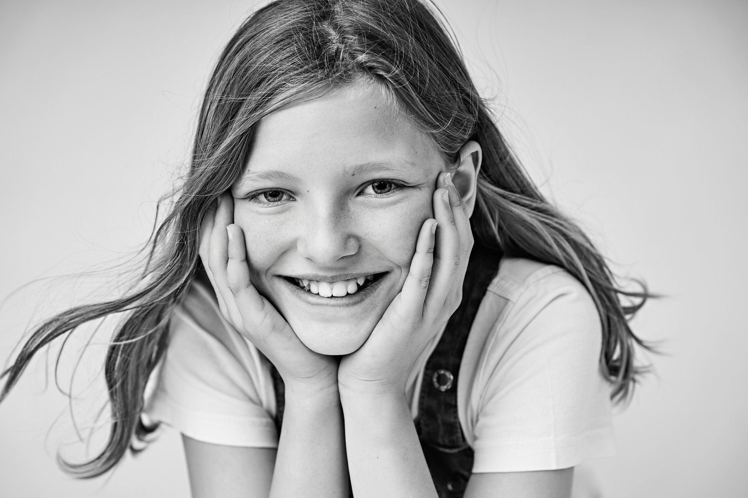 A timeless black-and-white children's studio portrait capturing a natural smile and genuine personality. Professional children's portrait photography by Lucas Gudaniec Photography, serving Annecy and Geneva.