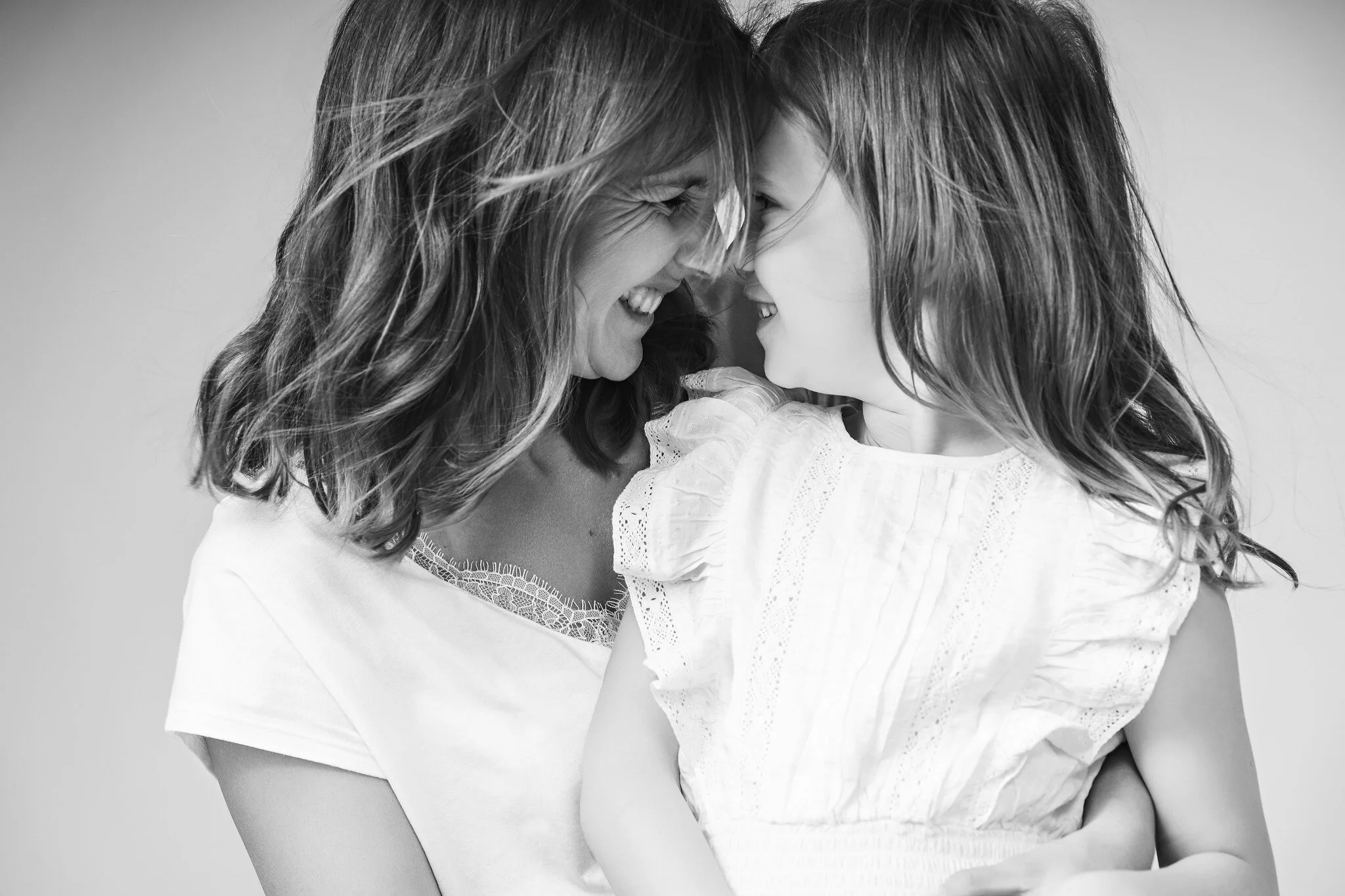 Black and white mother and daughter portrait capturing a joyful, intimate moment together..jpg