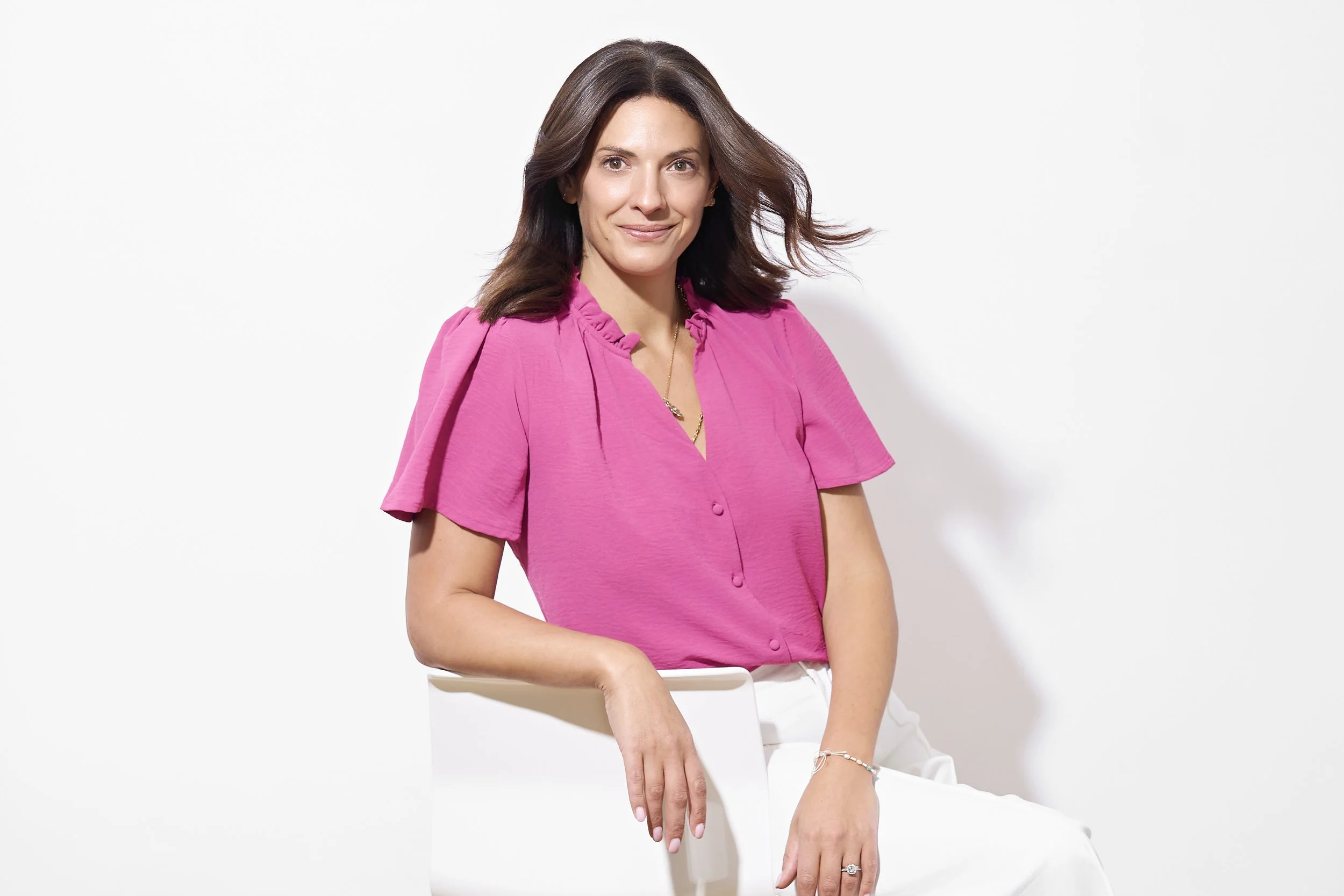 Professional modern headshot of a confident businesswoman wearing a pink blouse, photographed by Lucas Gudaniec Photography, serving Annecy and Geneva.