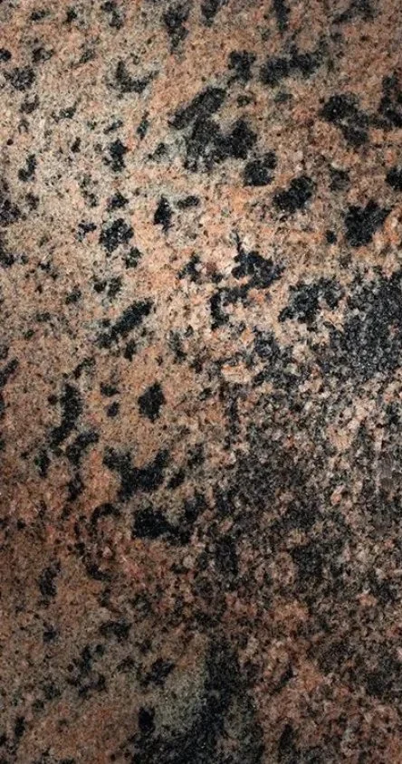 Close-up of a granite countertop with a speckled pattern in shades of brown, black, and beige.