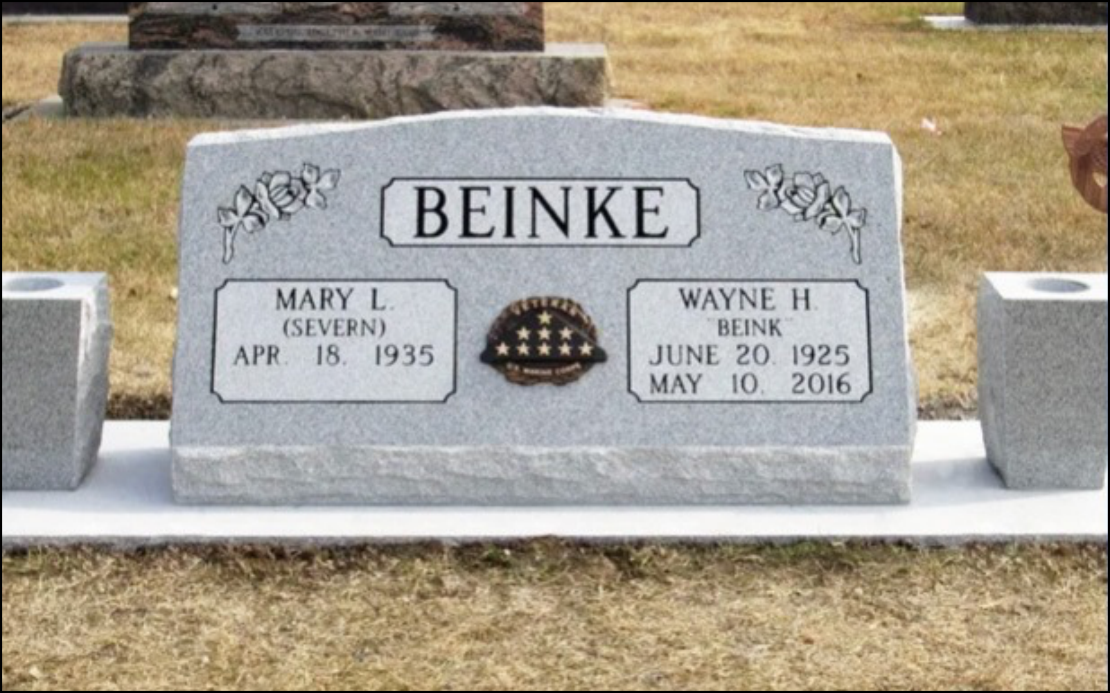 Gravestone with the surname 'Beinke,' featuring floral engravings, an American flag badge, and the names and birth and death dates of Mary L. (Severn) Beinke and Wayne H. Beinke.