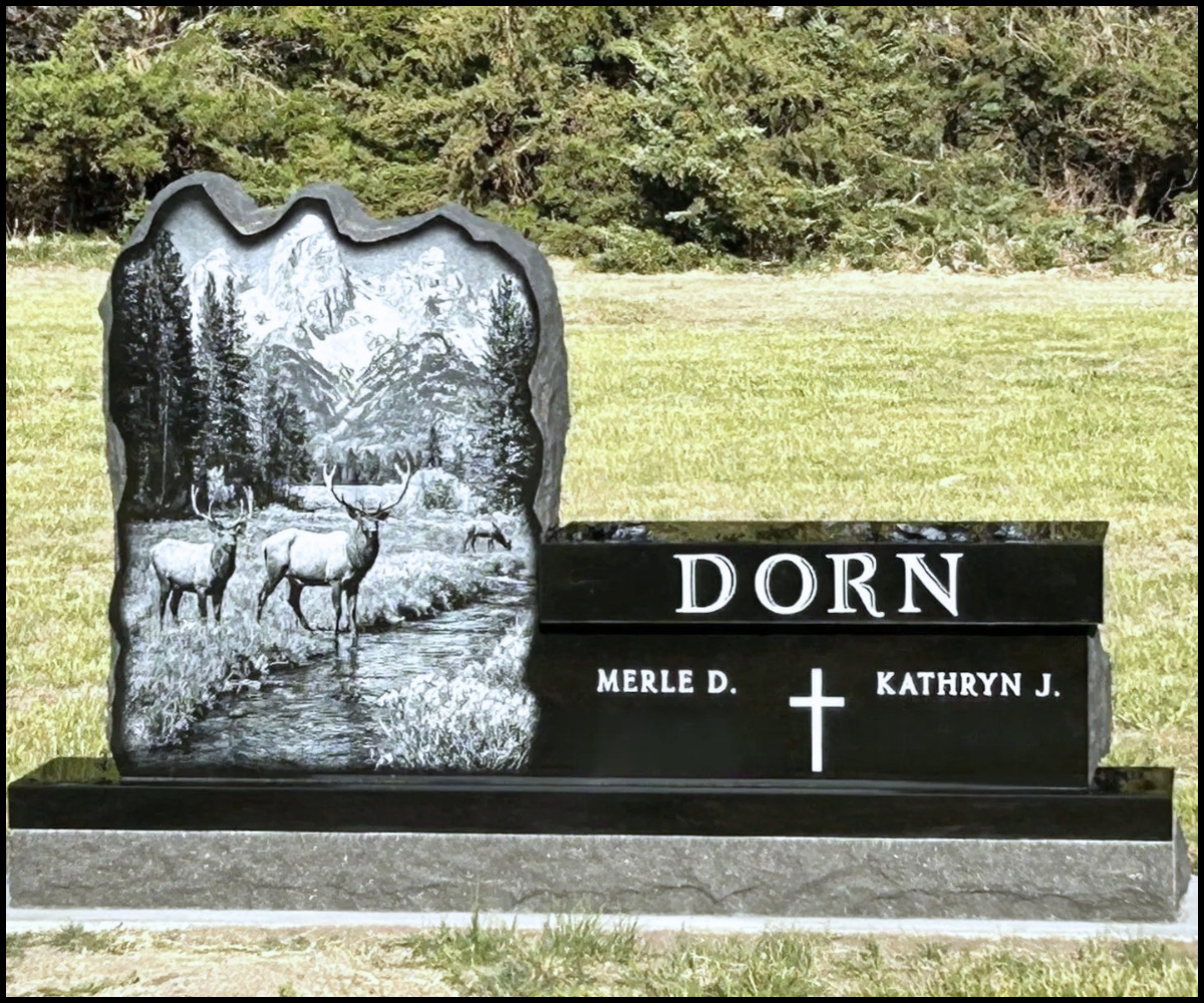 Gravestone with mountain and deer scene carved on left side, with name DORN on right side, and the names Merle D. and Kathryn J. below a cross.