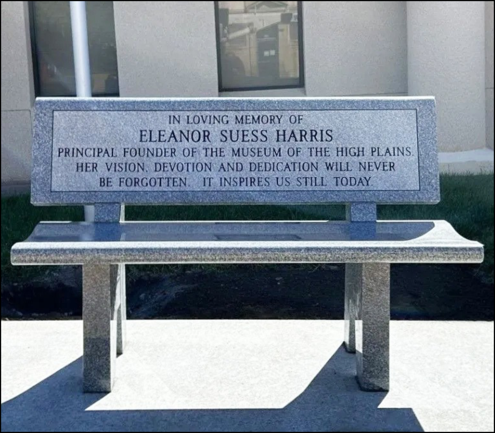 A stone memorial plaque on a bench dedicated to Eleanor Suess Harris, featuring an inscription honoring her contributions as founder of the Museum of the High Plains.
