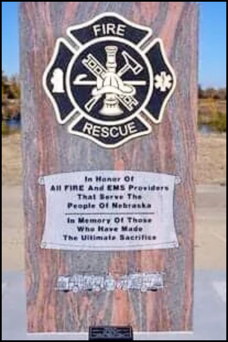 A memorial plaque featuring a fire rescue emblem with a firefighter's helmet, axes, and medical symbols, dedicated to Tennessee and EMS providers who serve Nebraska and honor those who made the ultimate sacrifice.