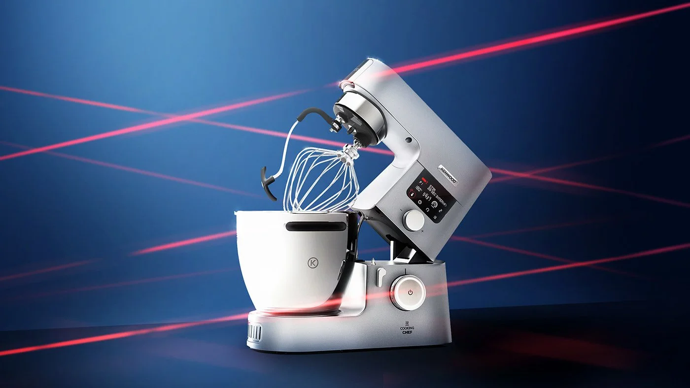 CGI render of a modern stand mixer with a digital control panel and a white bowl, with laser beams in the background.