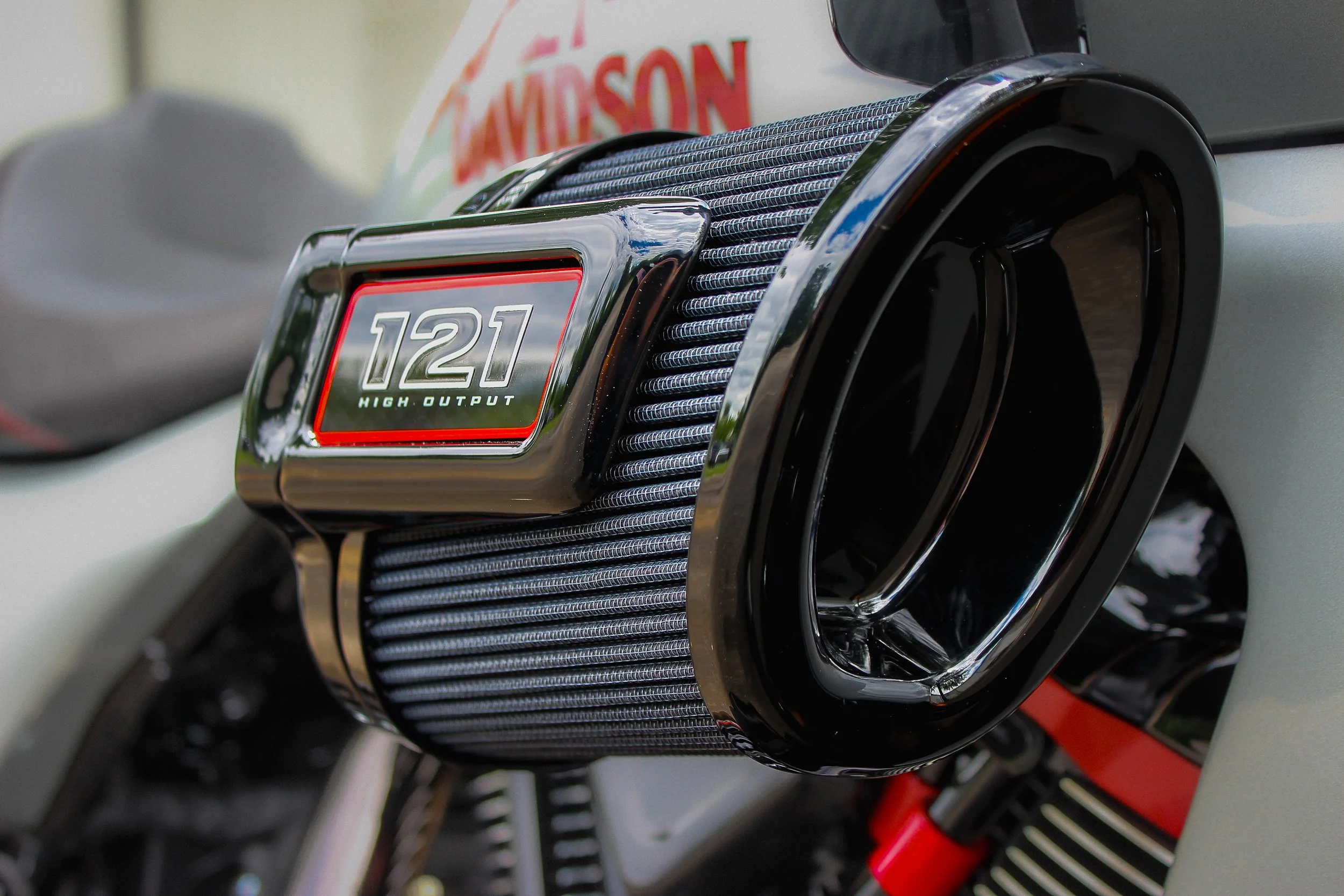 Close-up of high-performance car radiator with label "121 High Output" and a part of the vehicle's body and other components visible in the background.