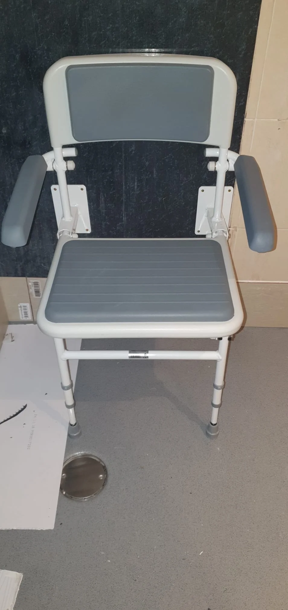 Gray and white adjustable shower chair with backrest, armrests, and rubber feet.