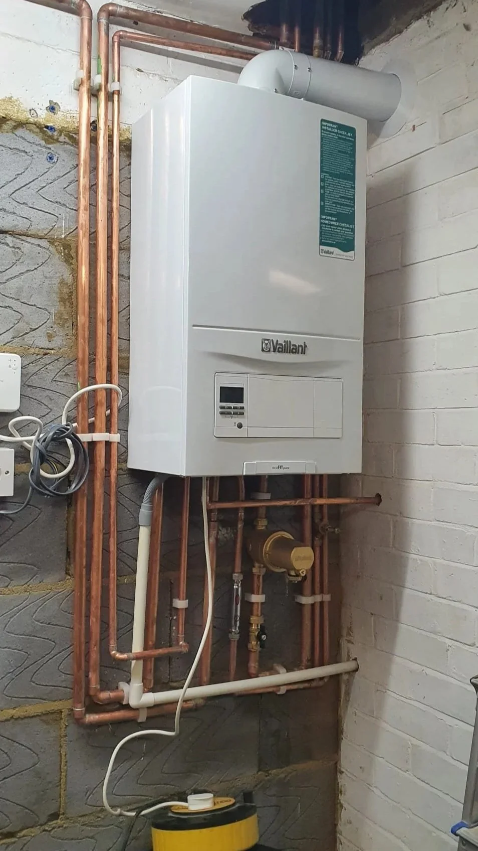 Wall-mounted Vaillant ecoFIT pure boiler with copper plumbing in a basement utility room