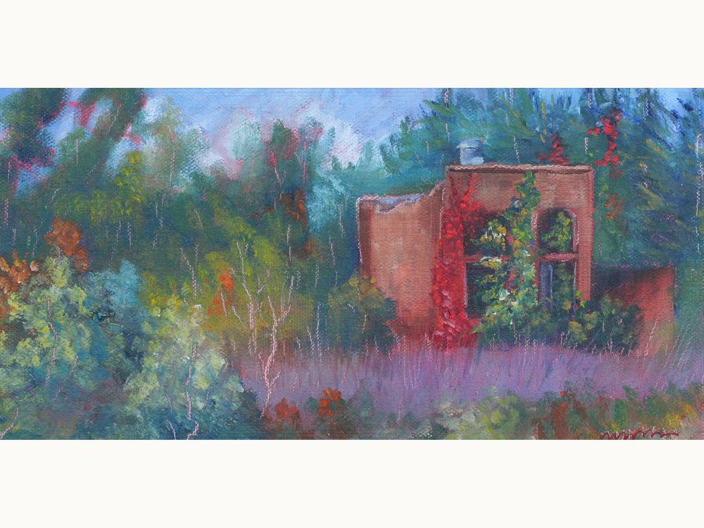 A vine-covered brick ruin in an overgrown field in fall.