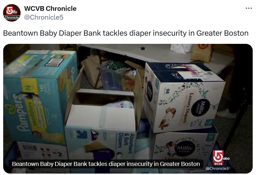 Stacked boxes of diapers, including Pampers, Millie Moon, and Luvs, on a table.