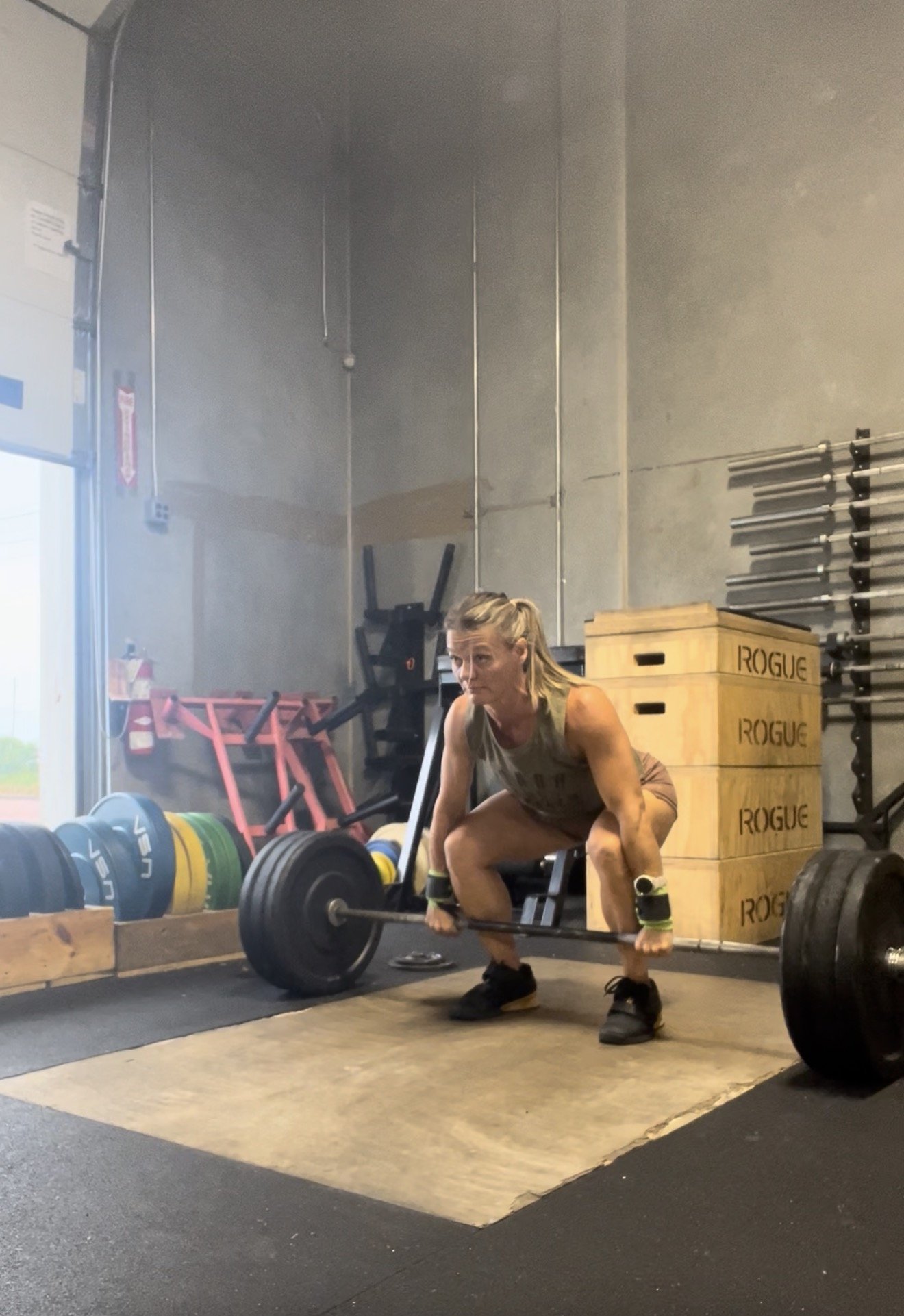 LeeAndra performing a barbell deadlift in the gym.