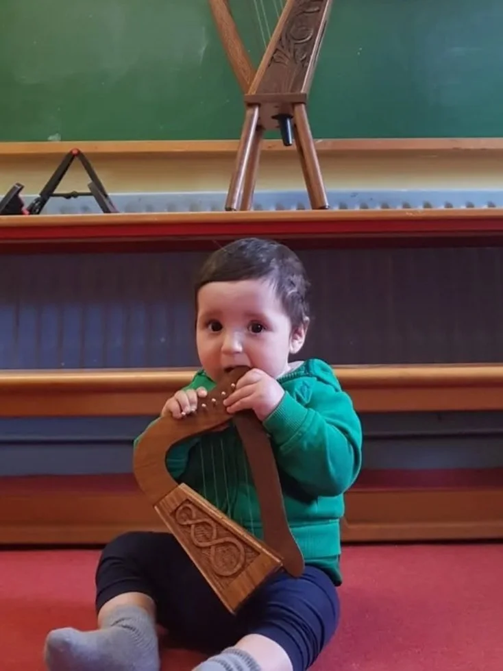 adorably cute baby with a tiny harp in his hands