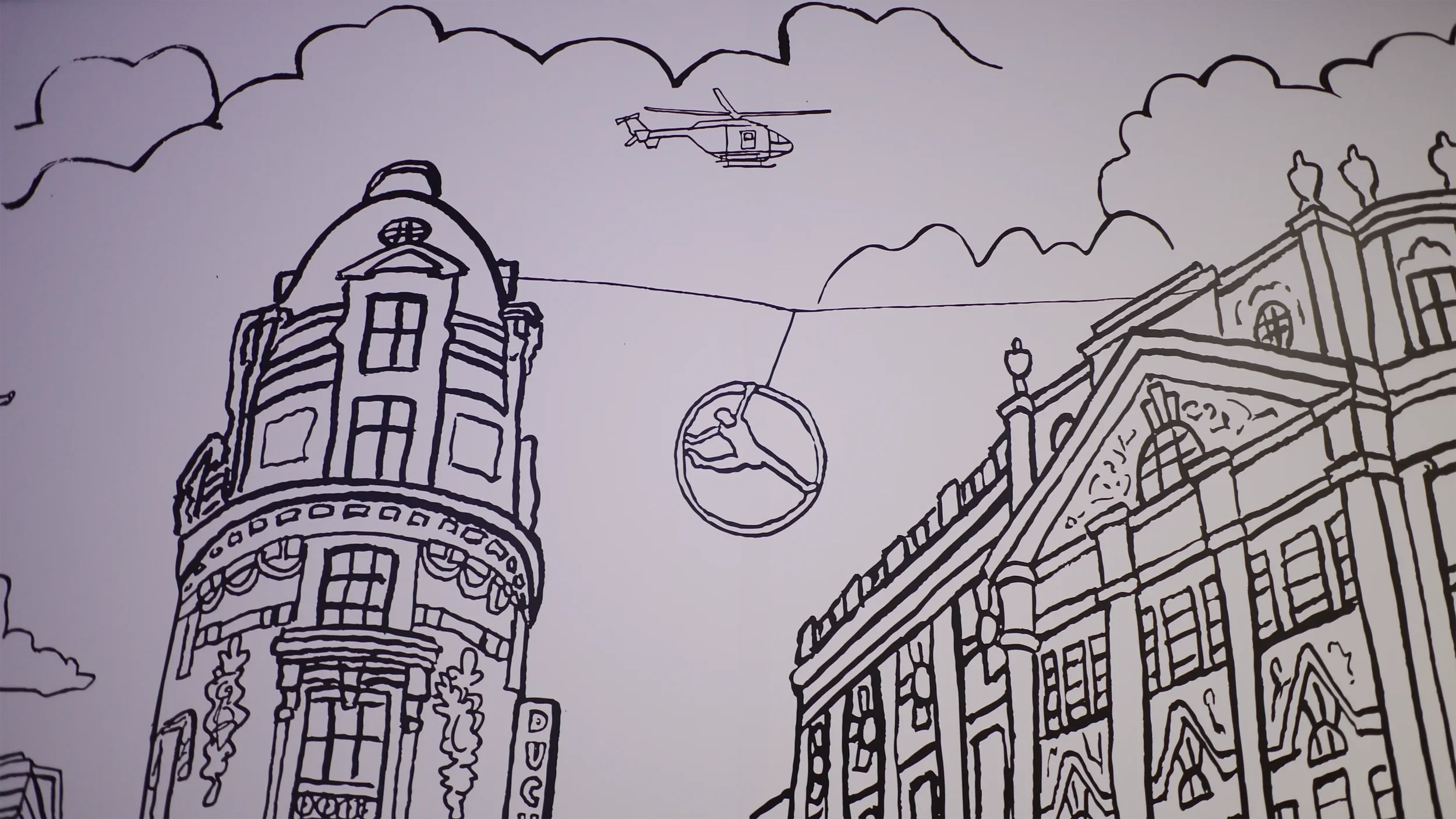 Physical wall detail showcasing hand-drawn architectural facades, cable cars, and helicopter motifs.